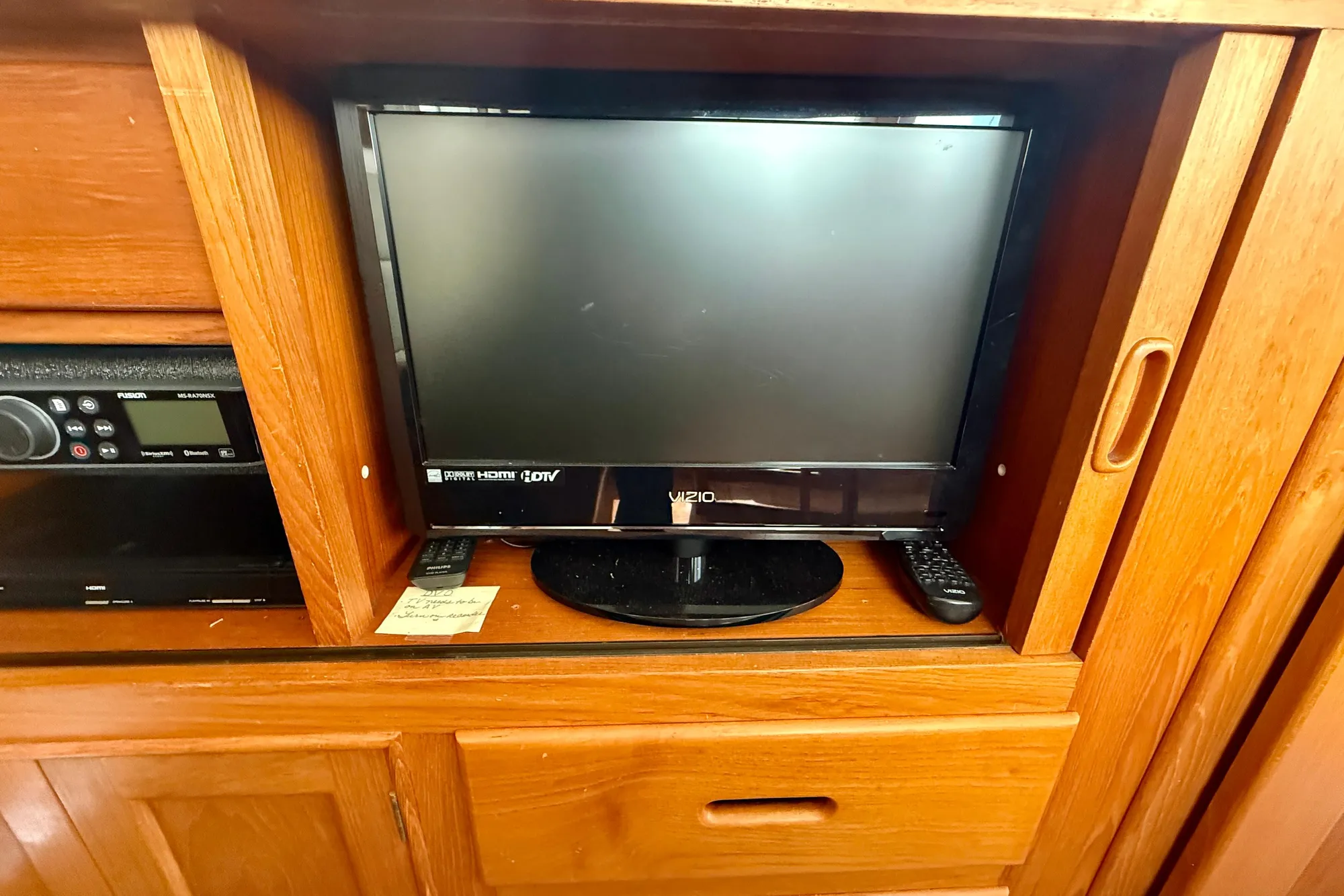 Vizio TV and remote in wooden cabinet on 1982 Grand Banks 42 Classic yacht.