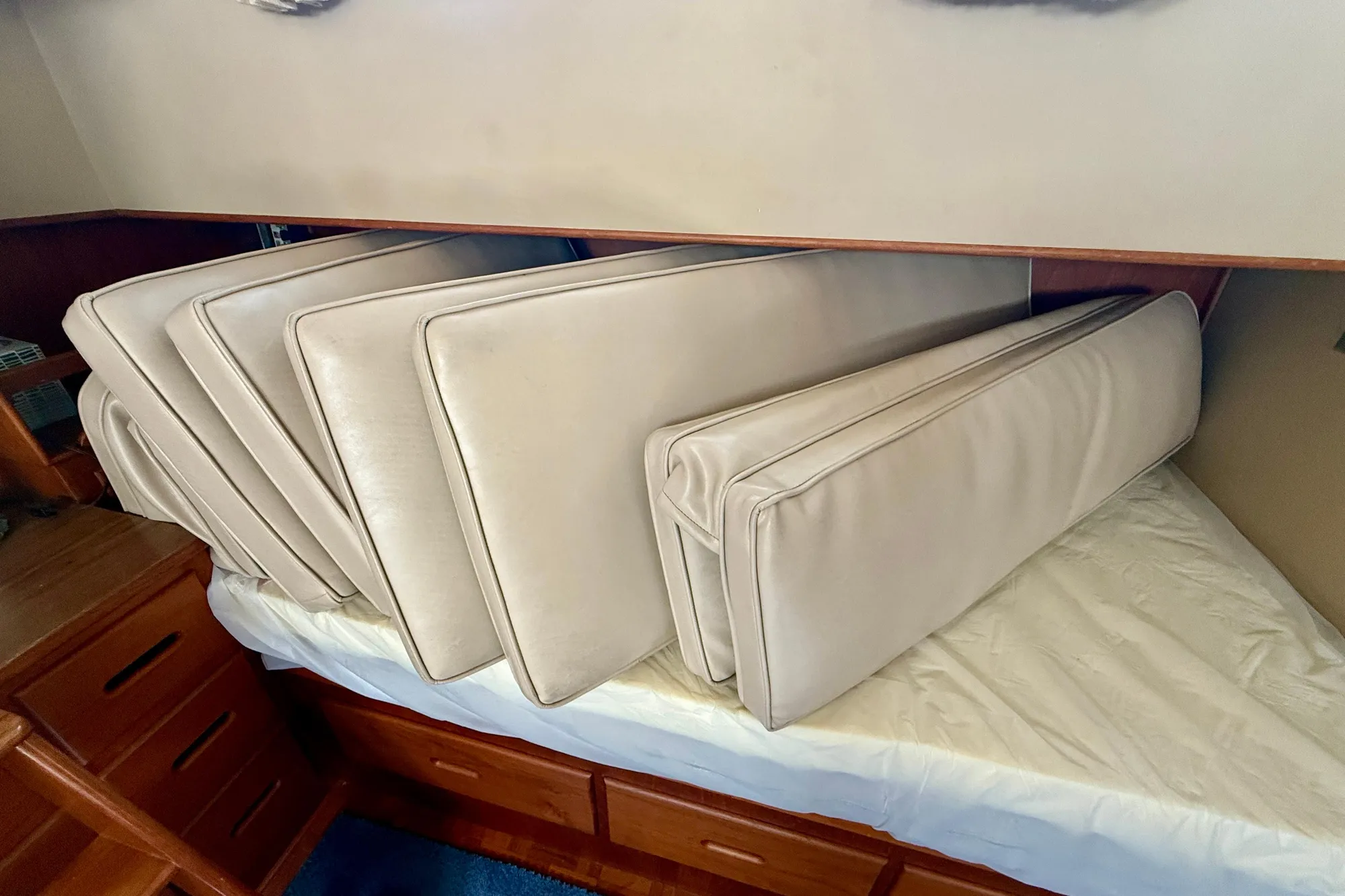 Cushions stacked on a bed inside a 1982 Grand Banks 42 Classic yacht cabin.