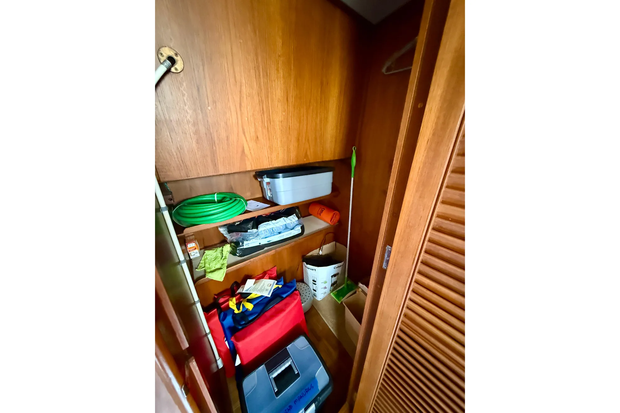 Storage closet on 1982 Grand Banks 42 Classic boat with various cleaning supplies.