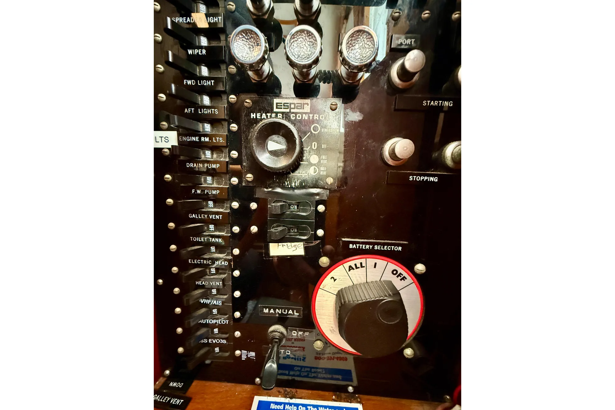 Control panel of a 1982 Grand Banks 42 Classic boat with various switches and dials.