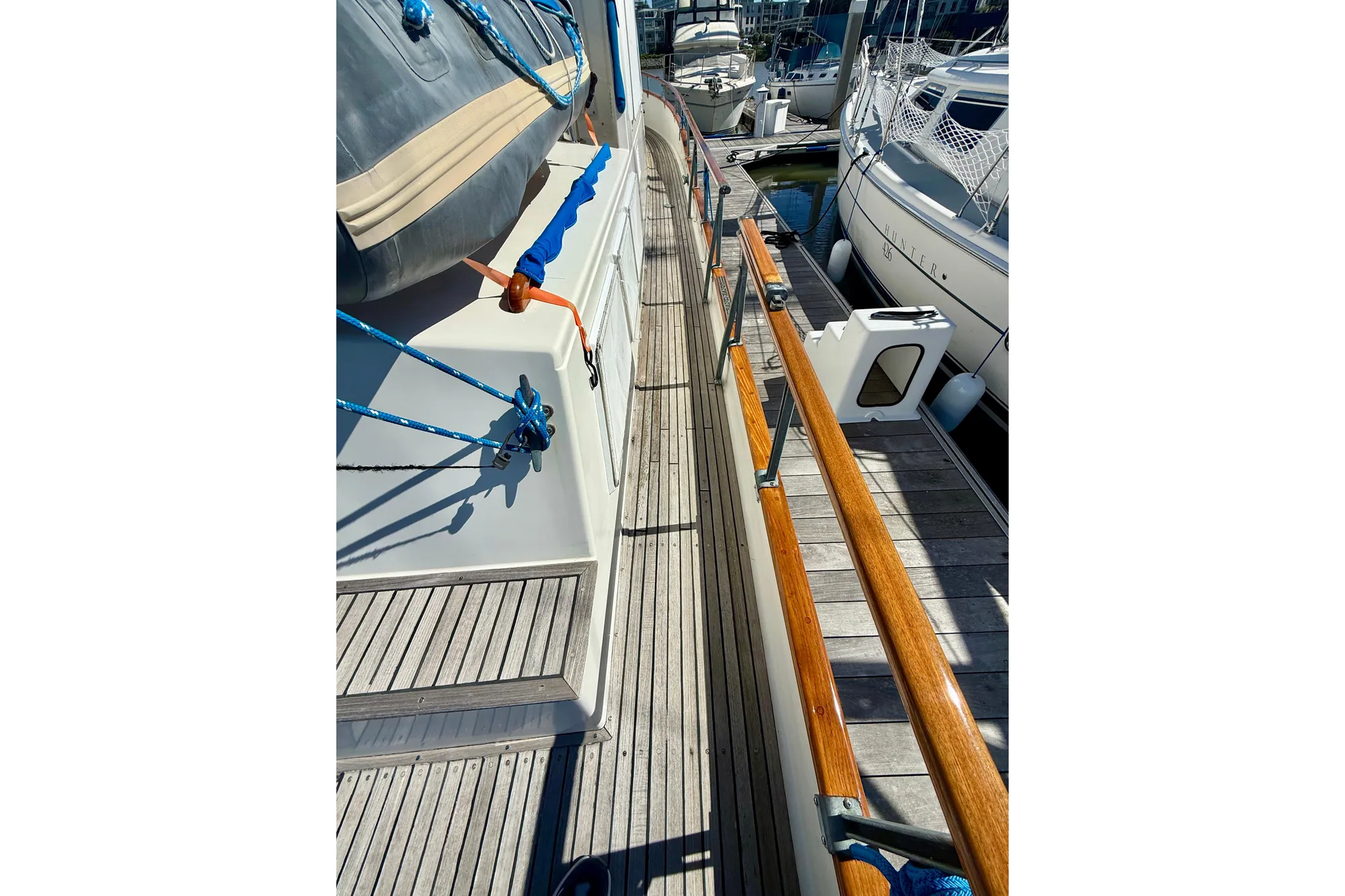 1982 Grand Banks 42 Classic yacht deck with wooden railings and docked boats.