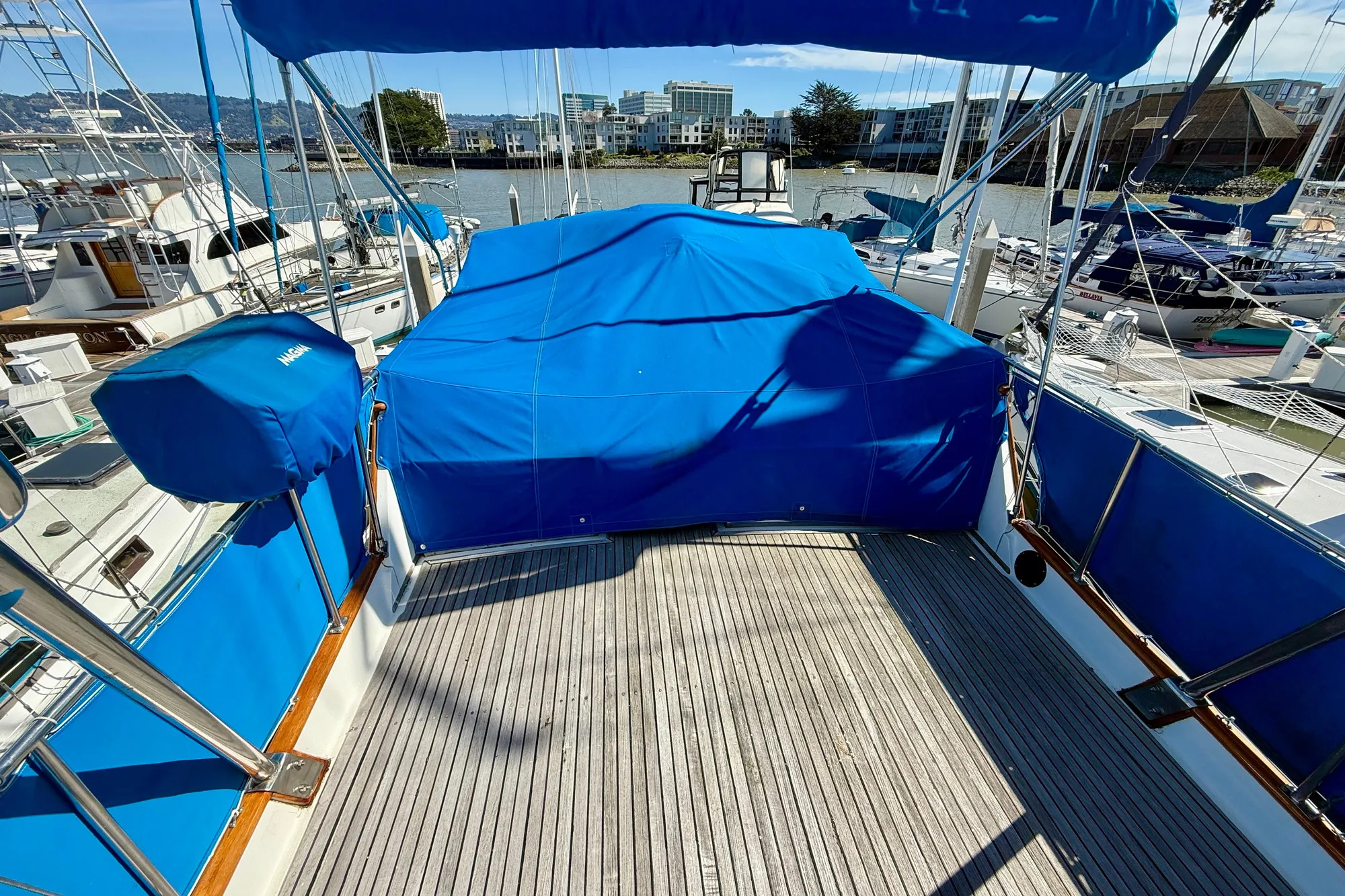 1982 Grand Banks 42 Classic yacht deck with blue covers in marina setting.