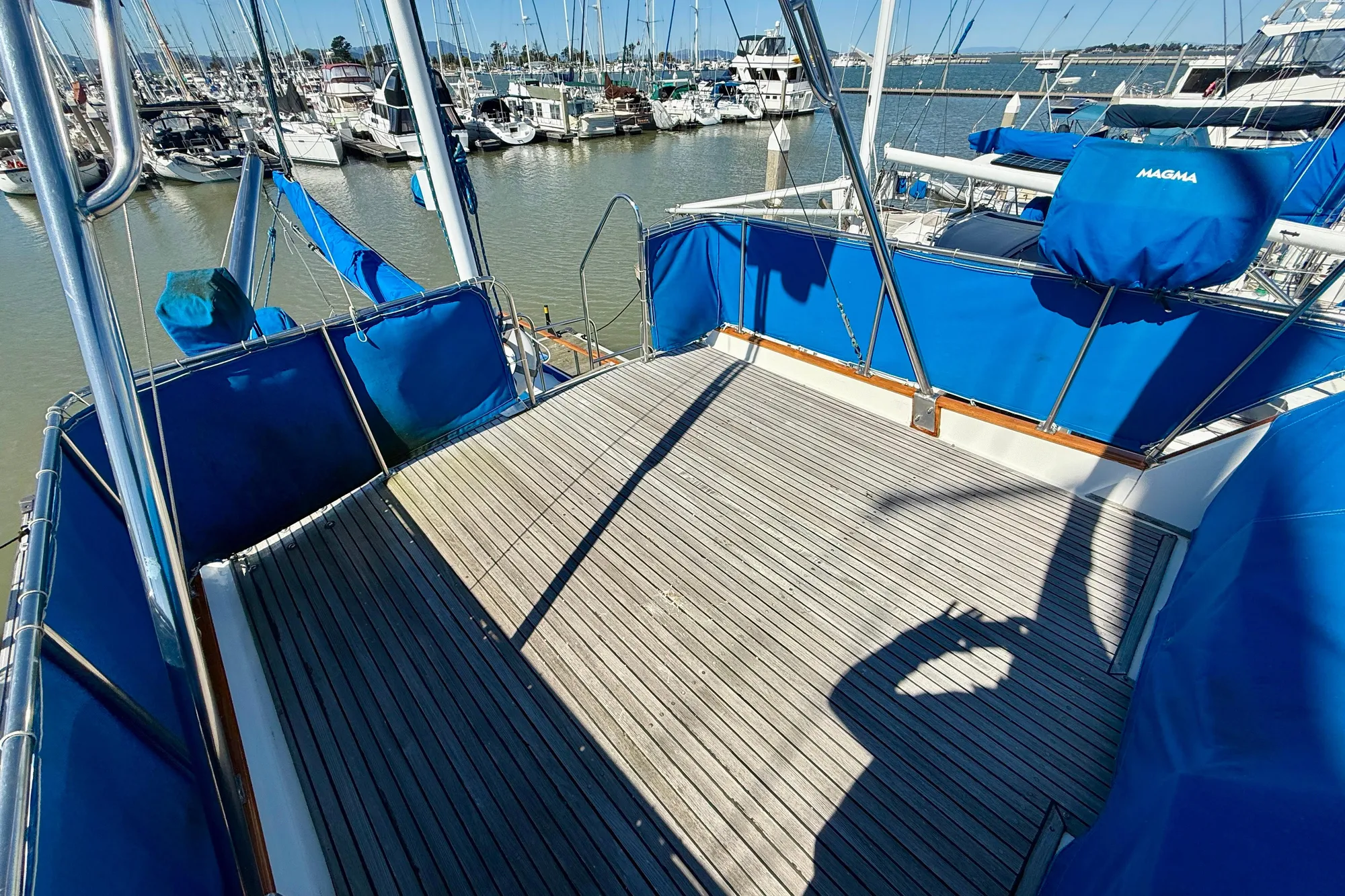 1982 Grand Banks 42 Classic yacht deck with blue covers in marina setting.