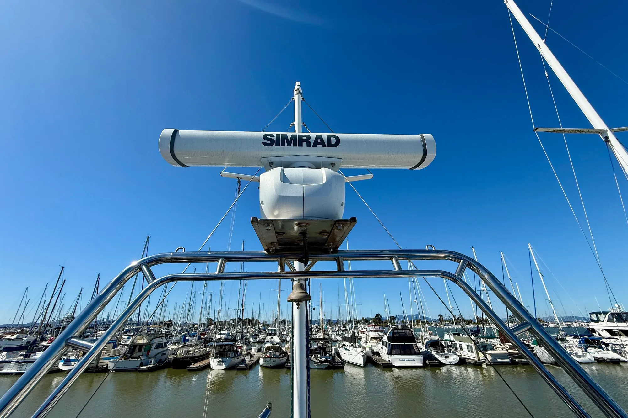 Radar equipment on 1982 Grand Banks 42 Classic yacht in marina under clear blue sky.