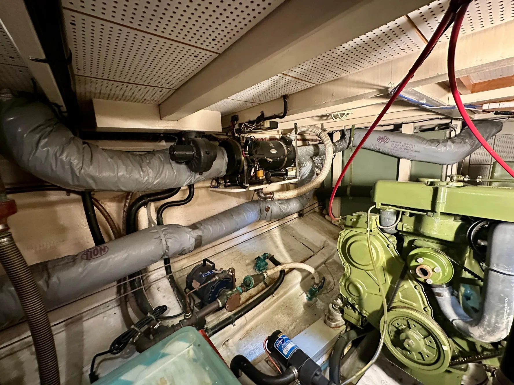 Engine room of a 1982 Grand Banks Classic boat, showcasing mechanical components and piping.