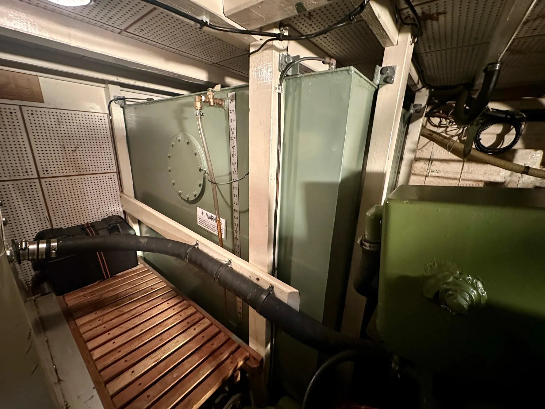 Engine room of 1982 Grand Banks Classic boat with machinery and pipes.