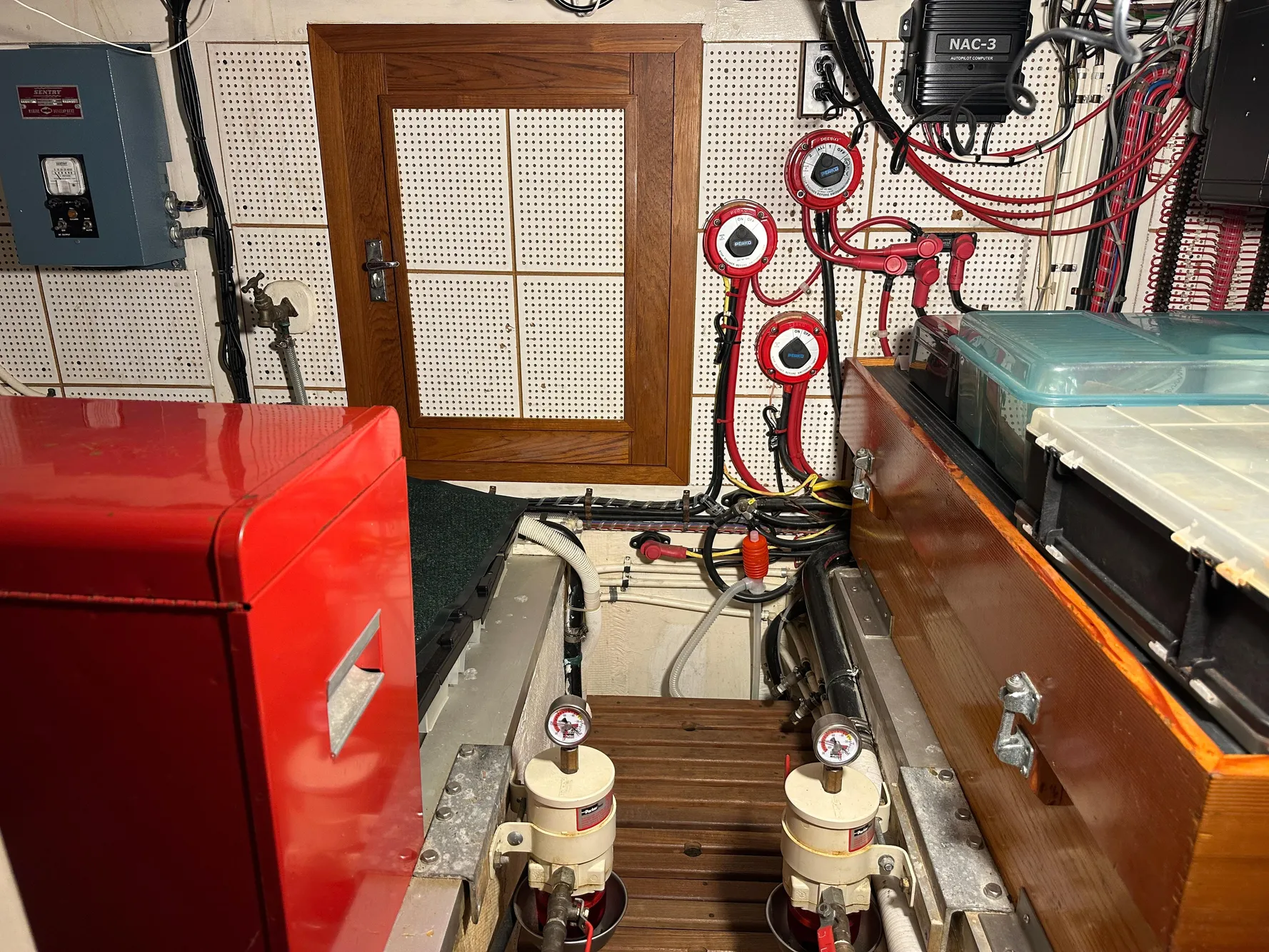 Engine room of a 1982 Grand Banks Classic boat with red and wooden components.
