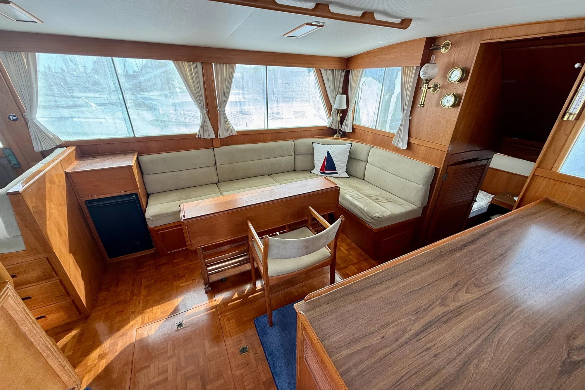 Interior of 1982 Grand Banks Classic yacht with wood finish and cozy seating area.