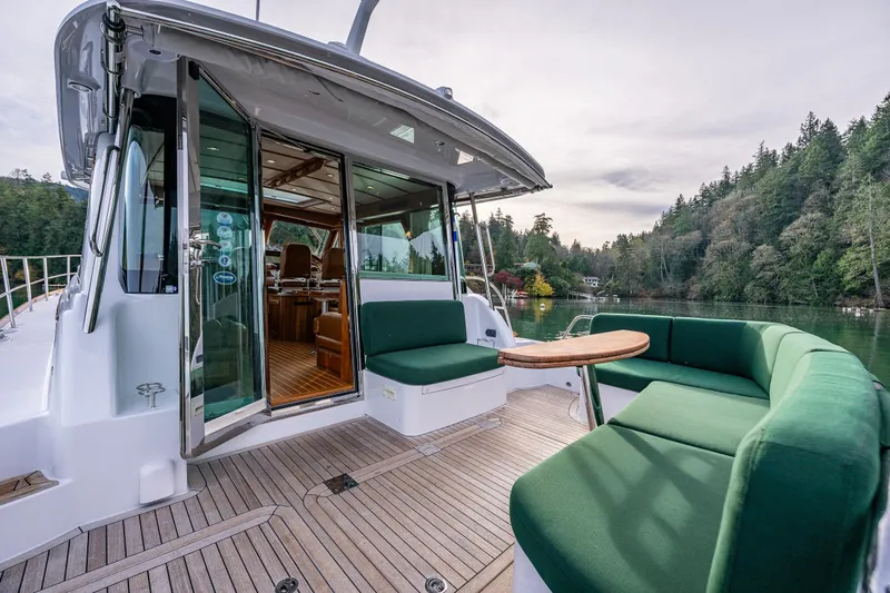 Sea Song Yacht Photos Pics 2019 Sabre 48 Salon Express yacht with green seating, docked in a scenic forested area.