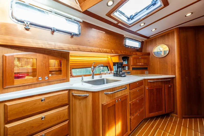 Sea Song Yacht Photos Pics Luxurious 2019 Sabre 48 Salon Express yacht kitchen with wooden cabinetry and modern fixtures.