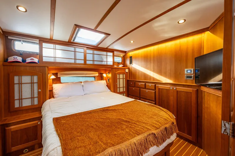 Sea Song Yacht Photos Pics Luxurious 2019 Sabre 48 Salon Express bedroom with wood paneling and cozy bedding.