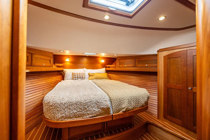 Sea Song Yacht Photos Pics Luxurious 2019 Sabre 48 Salon Express cabin with cozy bed and wooden interior.
