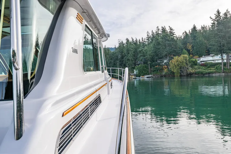 Sea Song Yacht Photos Pics 2019 Sabre 48 Salon Express yacht on tranquil water near forested shoreline.