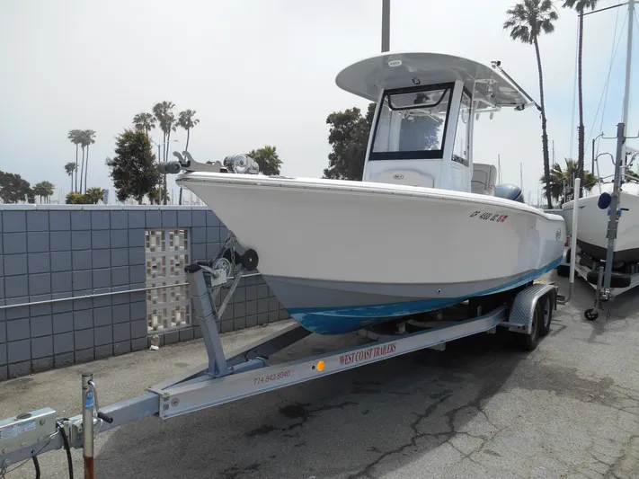 Yacht Photos Pics 2019 Sea Hunt Ultra 235 SE boat on trailer, parked outdoors near palm trees.