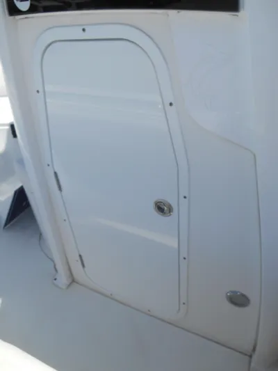  Yacht Photos Pics 2019 Sea Hunt Ultra 235 SE boat compartment door, white exterior.