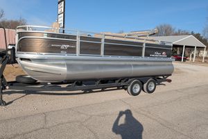 2024 Sun Tracker SportFish 20 DLX pontoon boat on a trailer, parked outdoors.
