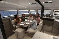 People dining inside a 2025 Nautitech 44 Open catamaran with ocean views.