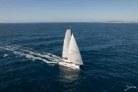 Sailing catamaran Nautitech 44 Open 2025 gliding on open sea under clear sky.
