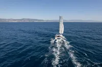 Sailing catamaran Nautitech 44 Open 2026 cruising on open sea with distant coastline.