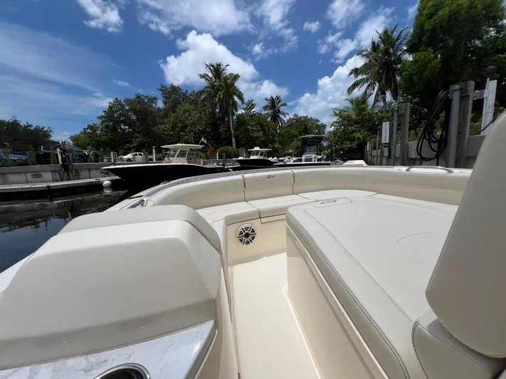  Yacht Photos Pics 2025 Scout 281 XSS boat docked, surrounded by lush greenery and clear blue sky.