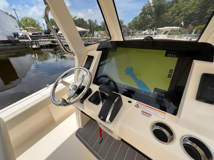  Yacht Photos Pics 2025 Scout 281 XSS boat dashboard with steering wheel and navigation display.