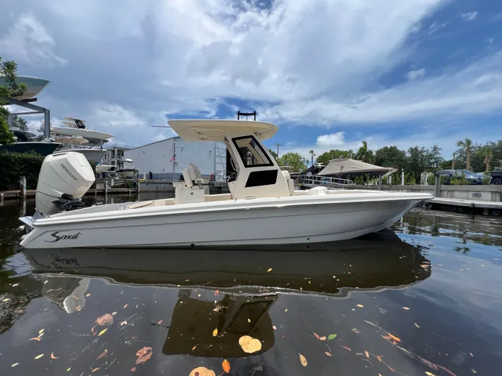  Yacht Photos Pics 2025 Scout 281 XSS boat docked on calm water under a partly cloudy sky.