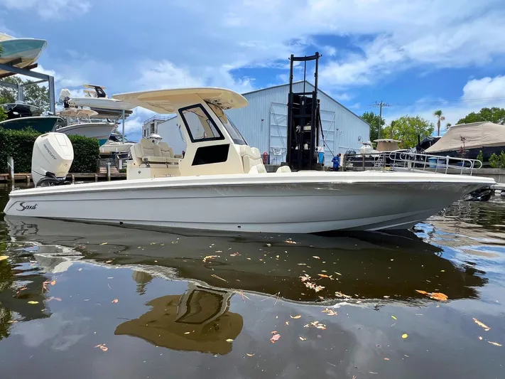  Yacht Photos Pics 2025 Scout 281 XSS boat docked on calm water, with clear blue sky background.