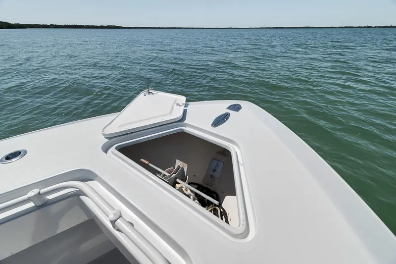  Yacht Photos Pics 2004 Contender 25 Tournament boat with open storage compartment on calm water.