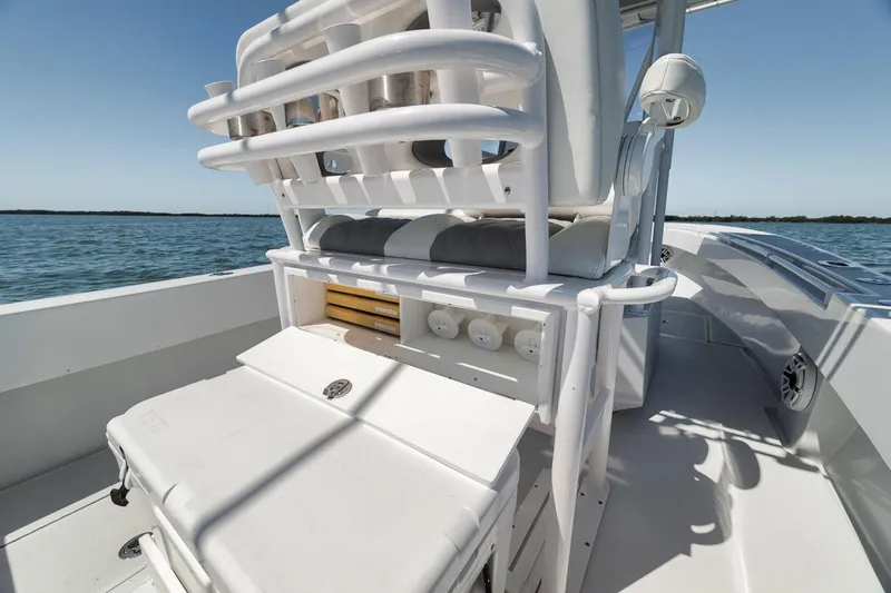 Yacht Photos Pics 2004 Contender 25 Tournament boat interior with rod holders and storage, on calm water.