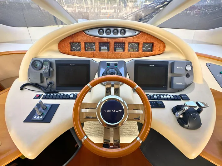 Andiamo Yacht Photos Pics Cockpit of 2010 Azimut 55E yacht with steering wheel and navigation controls.