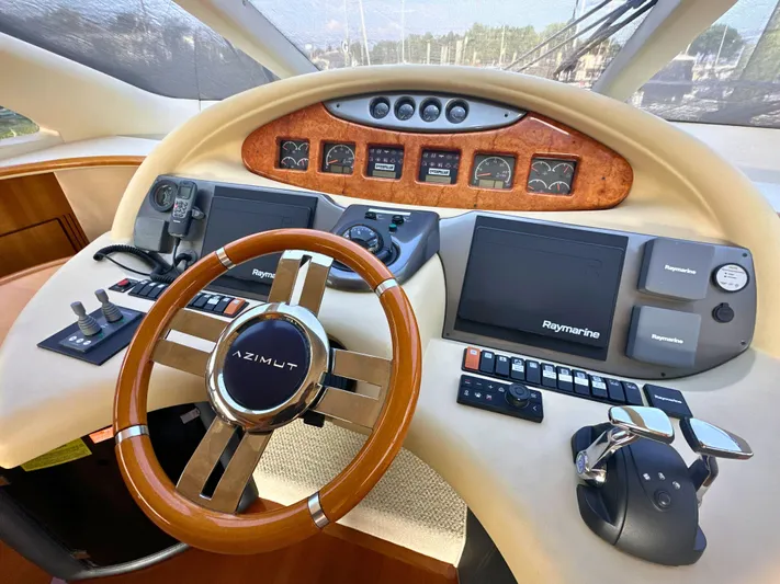 Andiamo Yacht Photos Pics Cockpit of 2010 Azimut 55E yacht with steering wheel and navigation controls.