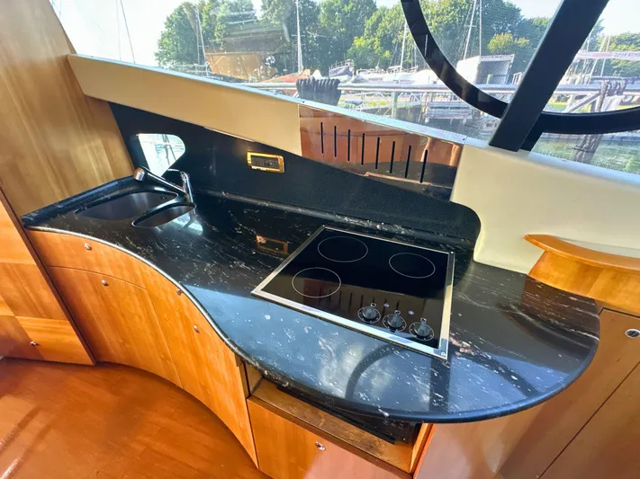 Andiamo Yacht Photos Pics Luxurious kitchen area in a 2010 Azimut 55E yacht with sleek black countertop.