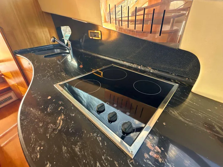 Andiamo Yacht Photos Pics Luxurious kitchen area in 2010 Azimut 55E yacht with sleek black countertop.