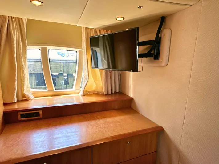 Andiamo Yacht Photos Pics Interior of 2010 Azimut 55E yacht with TV, wooden desk, and window.