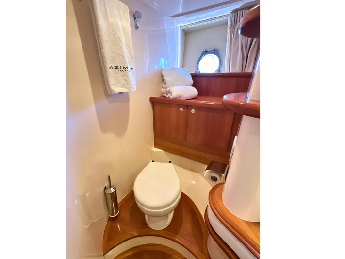 Andiamo Yacht Photos Pics Luxurious Azimut 55E 2010 yacht bathroom with wooden accents and porthole window.