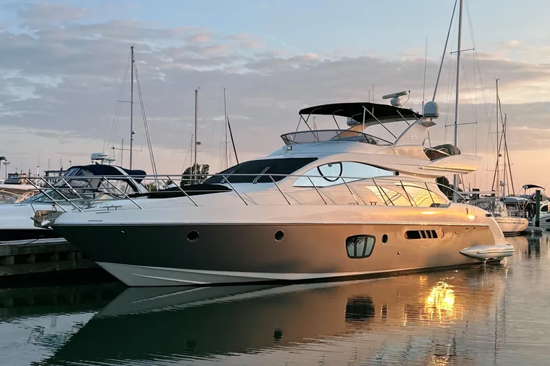 Andiamo Yacht Photos Pics Luxurious 2010 Azimut 55E yacht docked at sunset, reflecting on calm water.