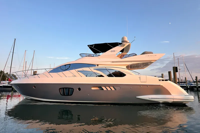 Andiamo Yacht Photos Pics 2010 Azimut 55E yacht docked at sunset, reflecting on calm water.