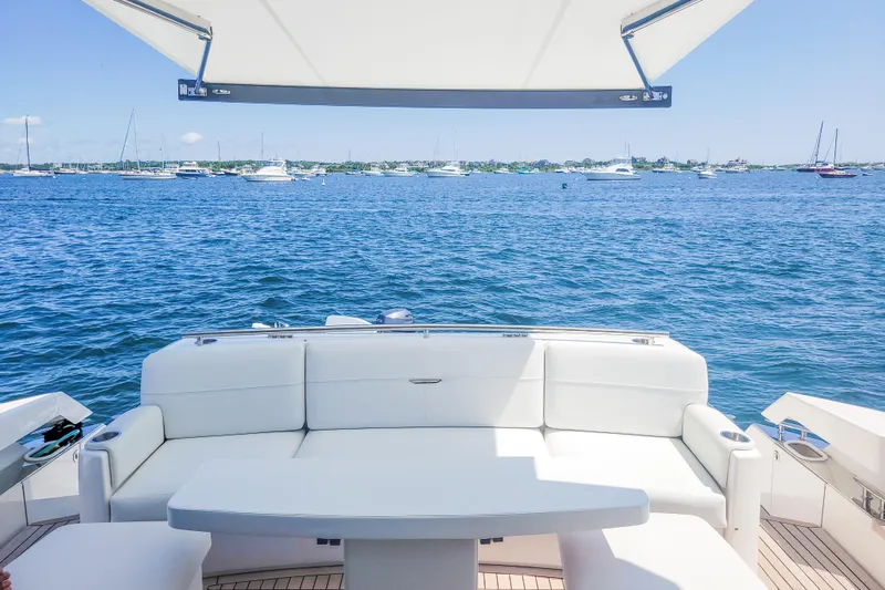 Courageous Yacht Photos Pics 2020 Tiara Yachts C53 Coupe with white seating, overlooking a serene ocean view.