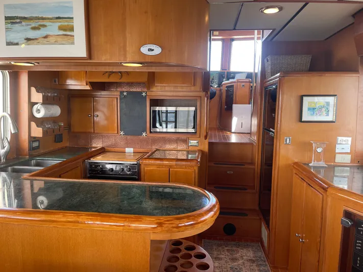 Sojourner Yacht Photos Pics Luxurious 2002 Transpacific Marine EAGLE 53 yacht interior with modern kitchen and wooden cabinetry.