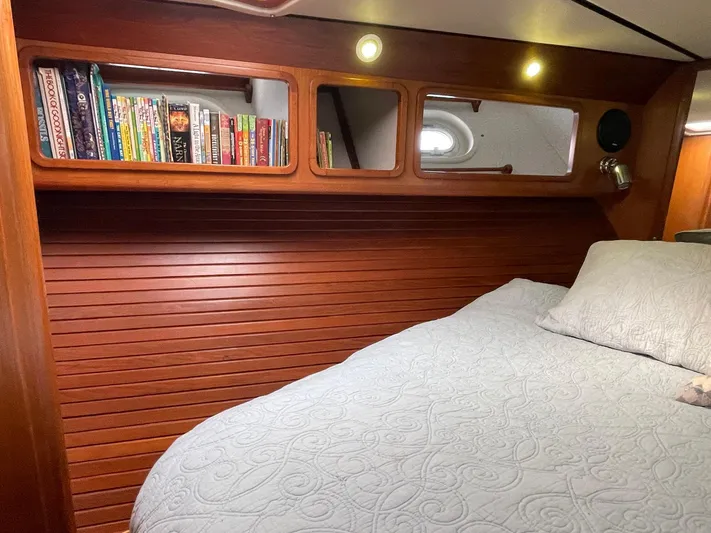 Sojourner Yacht Photos Pics Cozy cabin interior of 2002 Transpacific Marine EAGLE 53 with books and quilted bedding.