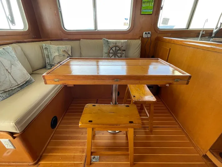 Sojourner Yacht Photos Pics Cozy interior of 2002 Transpacific Marine EAGLE 53 with wooden table and cushioned seating.