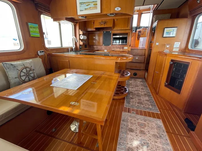 Sojourner Yacht Photos Pics Luxurious interior of 2002 Transpacific Marine EAGLE 53 yacht with wooden furnishings and dining area.