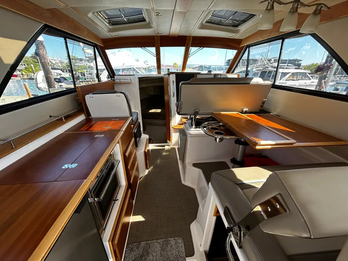 Blue Gail Yacht Photos Pics 2020 Cutwater C-30 Sedan interior with wood accents, dining area, and panoramic windows.