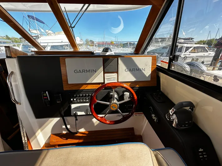 Blue Gail Yacht Photos Pics 2020 Cutwater C-30 Sedan helm with Garmin navigation, wooden accents, and marina view.