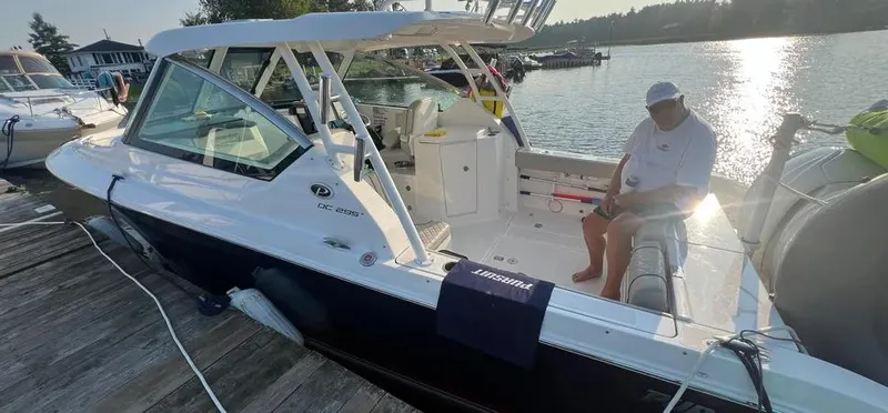  Yacht Photos Pics 2022 Pursuit DC 295 Dual Console boat docked with a person seated onboard.