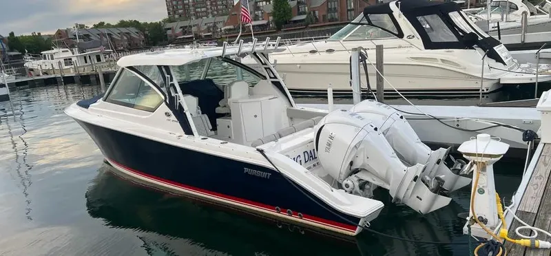  Yacht Photos Pics 2022 Pursuit DC 295 Dual Console boat docked at marina, featuring sleek design and powerful engines.