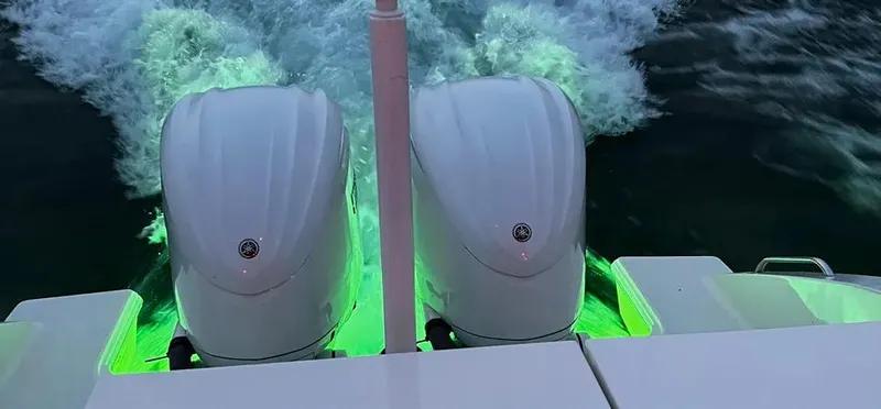 Yacht Photos Pics Twin engines on 2022 Pursuit DC 295 Dual Console, illuminated by green underwater lights.
