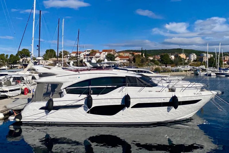 Placid Yacht Photos Pics 2019 Princess F55 yacht docked in a marina under a clear blue sky.