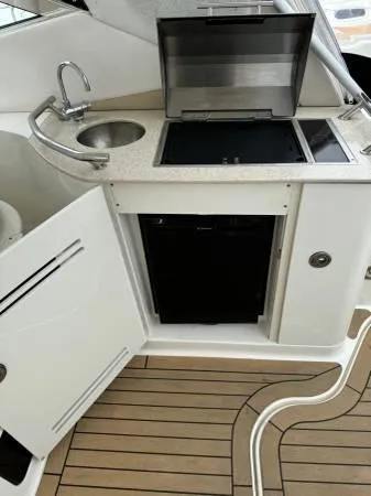  Yacht Photos Pics 2010 Sea Ray 370 Sundancer yacht kitchenette with sink, stove, and storage.