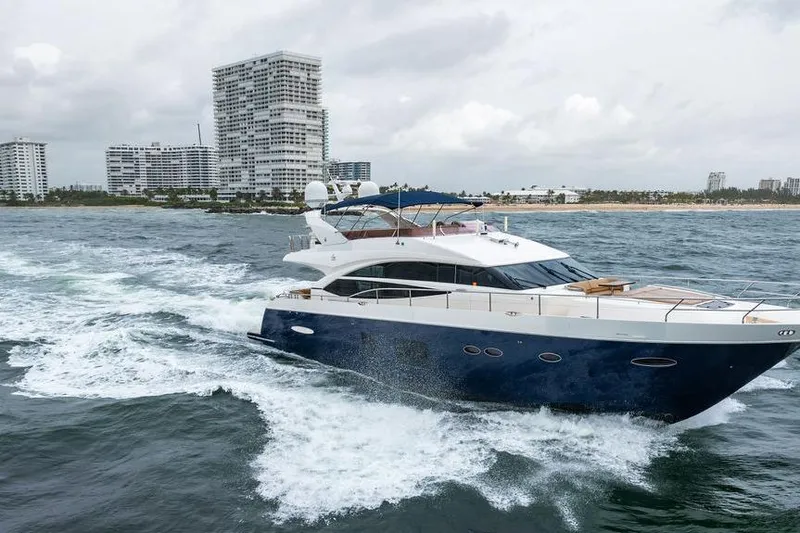  Yacht Photos Pics 2012 Princess Flybridge 72 Motor Yacht cruising near coastal cityscape.